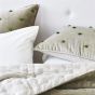 Designers Guild Sevanti Rectangular Quilted Cushion With Pom Poms in Dove
